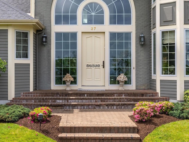 view of exterior entry featuring brick siding