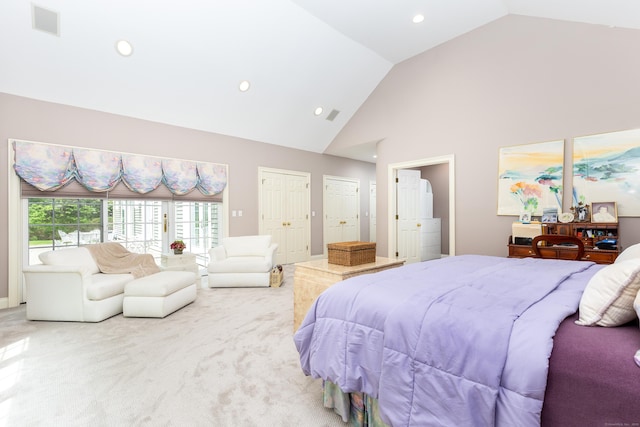 bedroom with light carpet, recessed lighting, high vaulted ceiling, and ensuite bathroom