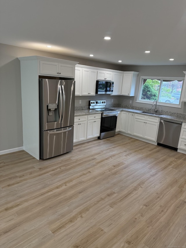 240 Centerbrook Rd Unit 240, Hamden, CT 06518 - kitchen featuring appliances with stainless steel finishes, a sink, light stone counters, white cabinetry, and light wood-type flooring