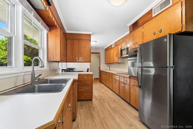 26 Thorson Rd, Oxford, CT 06478 - kitchen featuring appliances with stainless steel finishes, a sink, brown cabinets, and light wood-type flooring