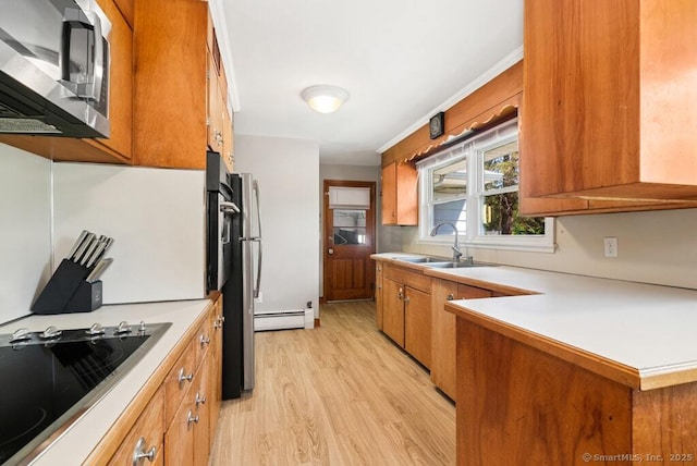 26 Thorson Rd, Oxford, CT 06478 - kitchen with stainless steel appliances, brown cabinets, light wood finished floors, and a baseboard heating unit