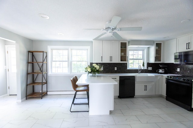 65 Lufkin Ln, Bristol, CT 06010 - kitchen featuring black appliances, light marble finish floors, a baseboard heating unit, a sink, and a kitchen breakfast bar