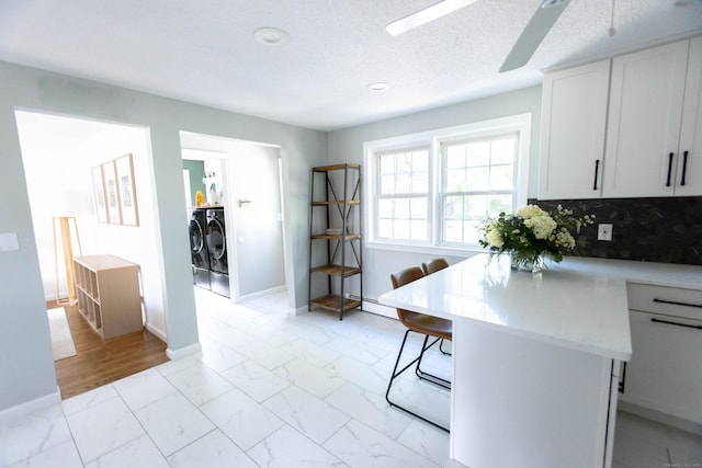 65 Lufkin Ln, Bristol, CT 06010 - kitchen with washing machine and dryer, light marble finish flooring, light countertops, ceiling fan, and a breakfast bar
