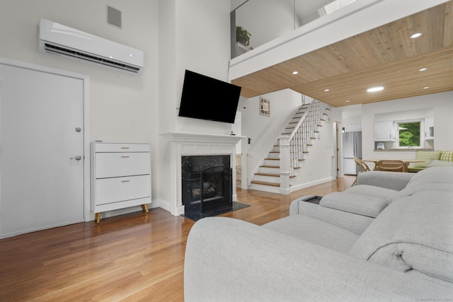48 Twin Oaks Unit 48, New Milford, CT 06776 - living area featuring an AC wall unit, stairway, a fireplace, light wood-style flooring, and wood ceiling
