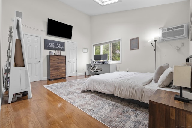 48 Twin Oaks Unit 48, New Milford, CT 06776 - bedroom featuring a wall unit AC, wood finished floors, high vaulted ceiling, and a desk
