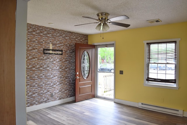 34 Joliet Ct, Groton, CT 06340 - foyer featuring baseboard heating, a textured ceiling, a ceiling fan, wood finished floors, and baseboards
