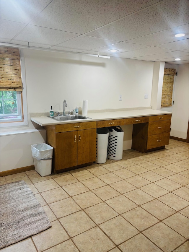 23 Dana Rd, Danbury, CT 06811 - kitchen featuring a sink, light countertops, a paneled ceiling, baseboards, and brown cabinetry