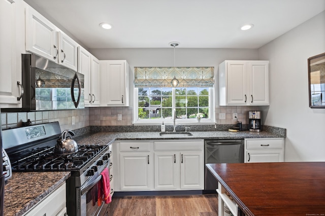 560 Silver Sands Rd Unit 902, East Haven, CT 06512 - kitchen with stainless steel appliances, a sink, decorative backsplash, wood finished floors, and white cabinetry