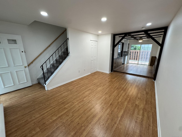 103 Kohanza St Unit E, Danbury, CT 06811 - unfurnished living room with wood finished floors, recessed lighting, stairs, and baseboards