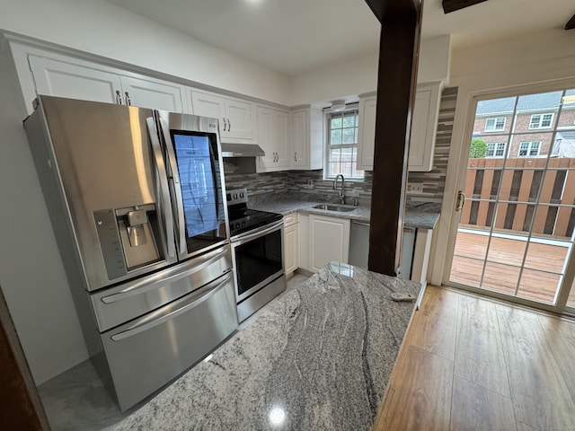 103 Kohanza St Unit E, Danbury, CT 06811 - kitchen with appliances with stainless steel finishes, white cabinets, a sink, light stone counters, and tasteful backsplash