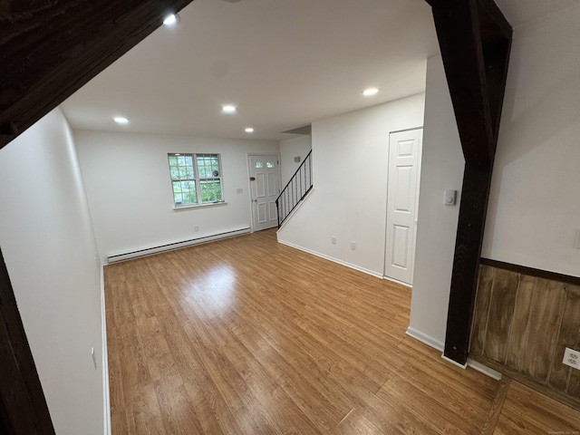 103 Kohanza St Unit E, Danbury, CT 06811 - unfurnished living room with a baseboard heating unit, stairs, light wood-style flooring, recessed lighting, and baseboards