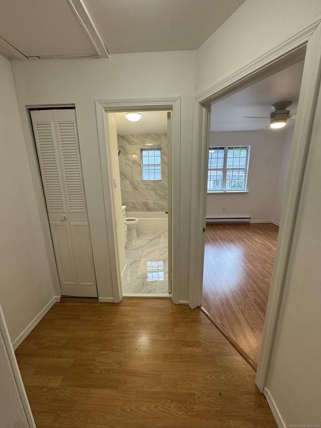 103 Kohanza St Unit E, Danbury, CT 06811 - corridor featuring wood finished floors, a baseboard radiator, healthy amount of natural light, and baseboards