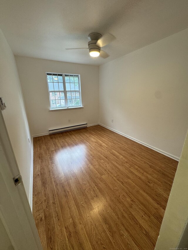 103 Kohanza St Unit E, Danbury, CT 06811 - unfurnished room with baseboard heating, wood finished floors, a ceiling fan, and baseboards