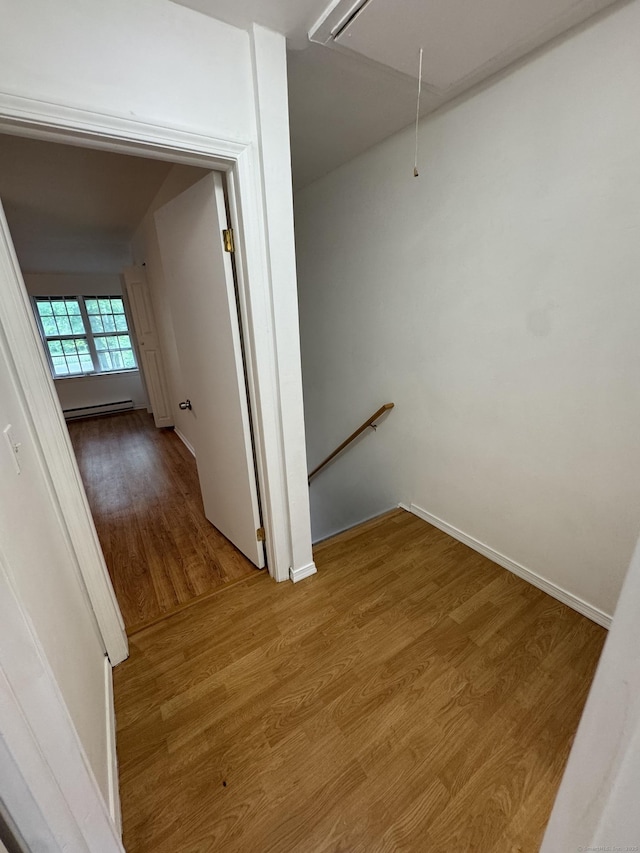 103 Kohanza St Unit E, Danbury, CT 06811 - corridor with attic access, wood finished floors, an upstairs landing, a baseboard heating unit, and baseboards
