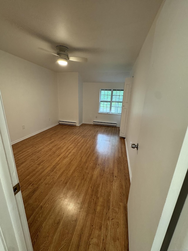 103 Kohanza St Unit E, Danbury, CT 06811 - spare room with a baseboard heating unit, wood finished floors, ceiling fan, and baseboards