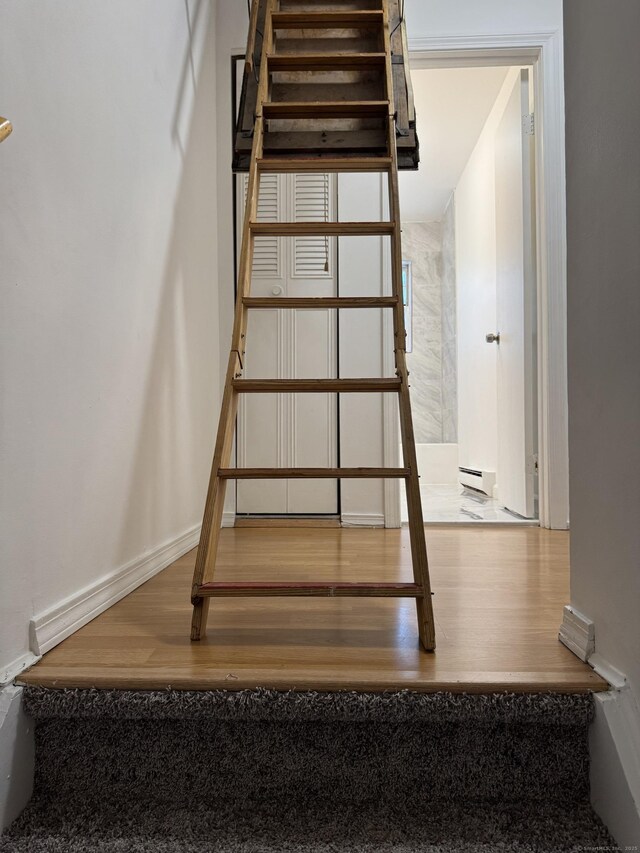 103 Kohanza St Unit E, Danbury, CT 06811 - stairs featuring a baseboard radiator, wood finished floors, and baseboards