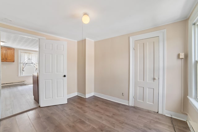 4 Granite St, Waterbury, CT 06706 - unfurnished bedroom with a baseboard heating unit, light wood-style floors, baseboards, and ornamental molding