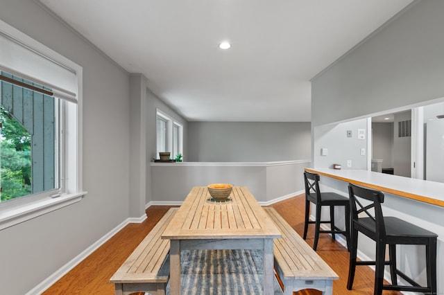 dining room with baseboards, wood finished floors, and recessed lighting