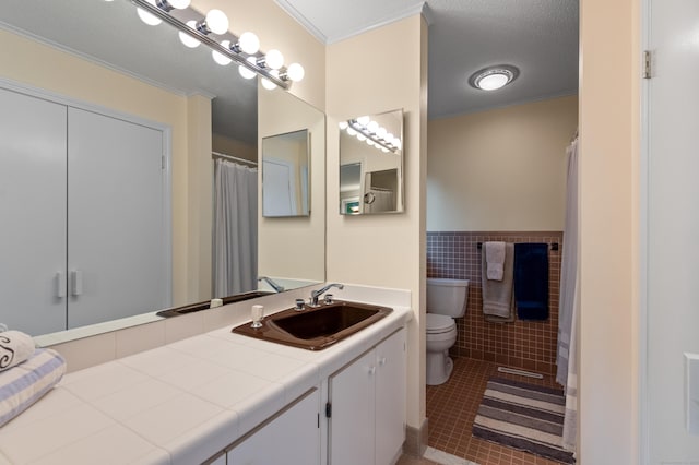 full bath featuring toilet, tile patterned floors, tile walls, a wainscoted wall, and crown molding