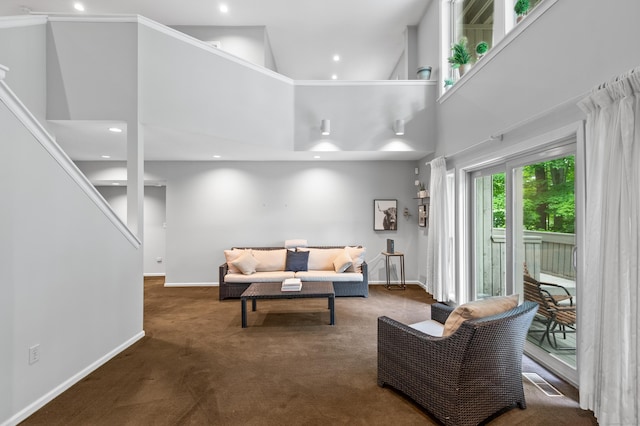 carpeted living room with baseboards, a high ceiling, and recessed lighting