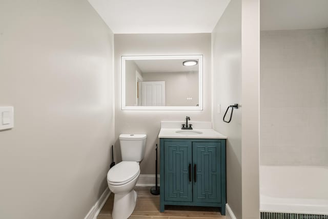 253 N Main St, Norwich, CT 06360 - bathroom featuring toilet, a tub to relax in, vanity, wood finished floors, and baseboards