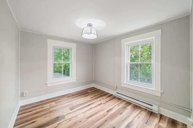 253 N Main St, Norwich, CT 06360 - empty room featuring a baseboard radiator, healthy amount of natural light, light wood finished floors, and baseboards