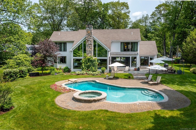 8 Heritage Island Rd, New Fairfield, CT 06812 - rear view of house featuring a patio area, a chimney, a pool with connected hot tub, a yard, and roof with shingles
