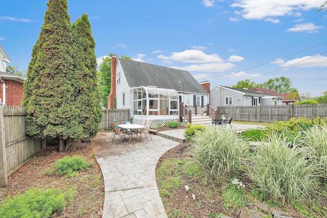 239 Bellevue Ave, West Haven, CT 06516 - rear view of house with a sunroom, a patio, a fenced backyard, a chimney, and a deck