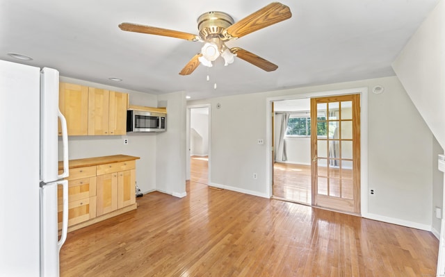 18 Glover Ave, Newtown, CT 06470 - kitchen with freestanding refrigerator, stainless steel microwave, light brown cabinets, and light wood finished floors