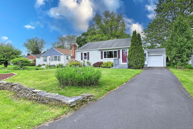 view of front of house with asphalt driveway, a front lawn, roof with shingles, and a garage