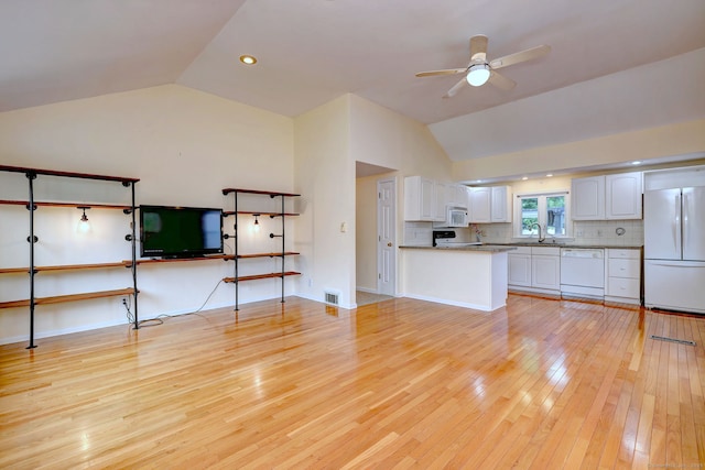 unfurnished living room featuring lofted ceiling, a ceiling fan, light wood-type flooring, and a sink