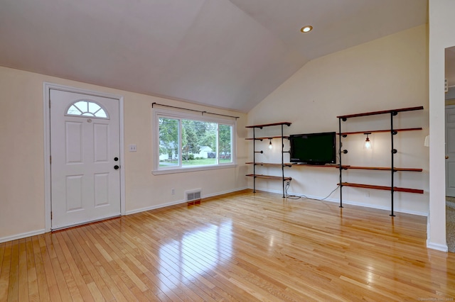 entryway with light wood-type flooring, vaulted ceiling, and baseboards
