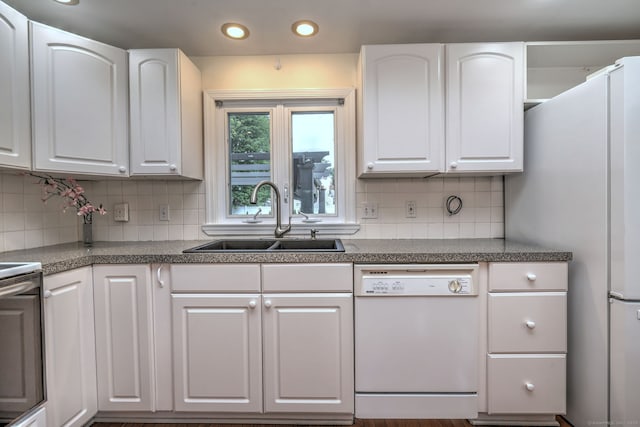 kitchen with white dishwasher, a sink, white cabinetry, and recessed lighting