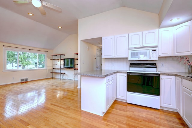 kitchen with white microwave, range with electric cooktop, lofted ceiling, a peninsula, and white cabinets