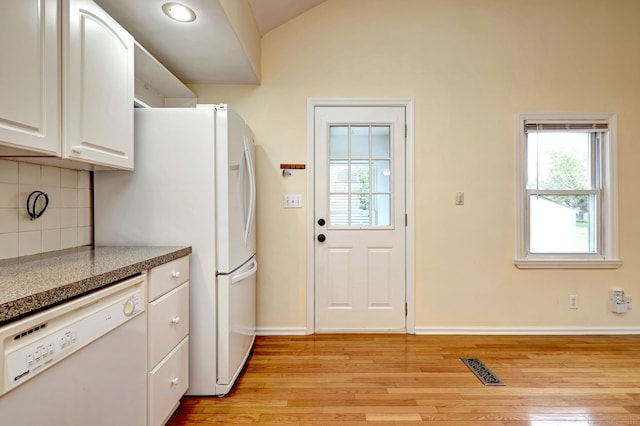 kitchen featuring white appliances, tasteful backsplash, light wood finished floors, white cabinets, and lofted ceiling