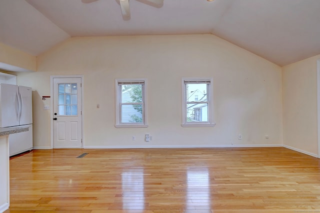 unfurnished living room featuring lofted ceiling, light wood finished floors, a ceiling fan, and baseboards
