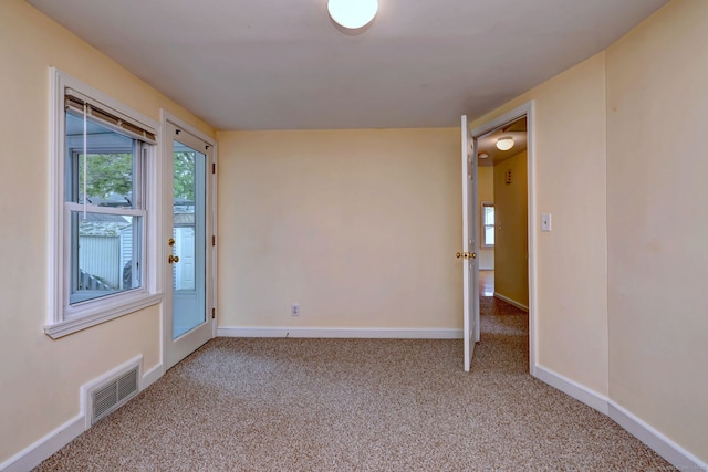 unfurnished room featuring light carpet, plenty of natural light, and baseboards