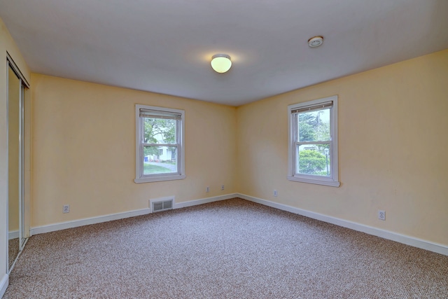unfurnished room with carpet, baseboards, and a smoke detector