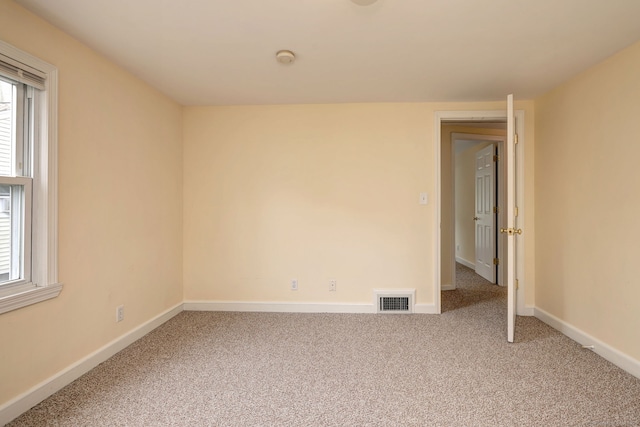 carpeted spare room featuring baseboards