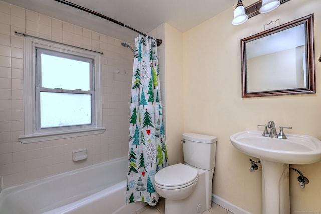 full bath featuring toilet, shower / tub combo with curtain, and a sink