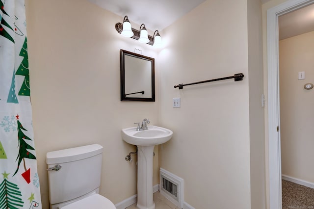 bathroom with toilet, a sink, baseboards, and a shower with shower curtain