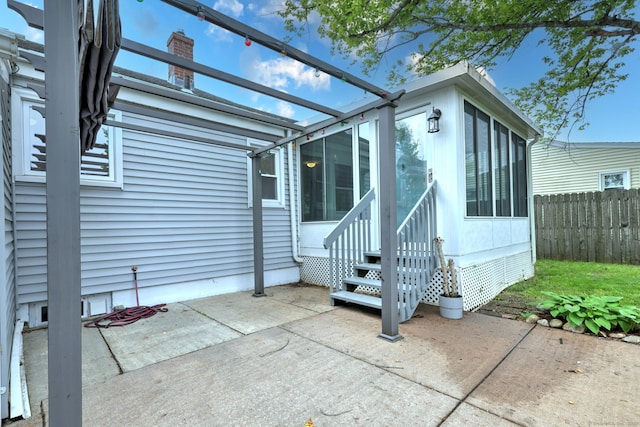 view of patio with entry steps, a pergola, and a sunroom