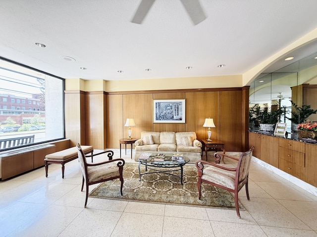 1 Strawberry Hill Ct Apt 1A, Stamford, CT 06902 - living area featuring dark aggregate flooring, wooden walls, and a ceiling fan