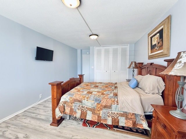 1 Strawberry Hill Ct Apt 1A, Stamford, CT 06902 - bedroom featuring a closet, light wood-type flooring, and baseboards