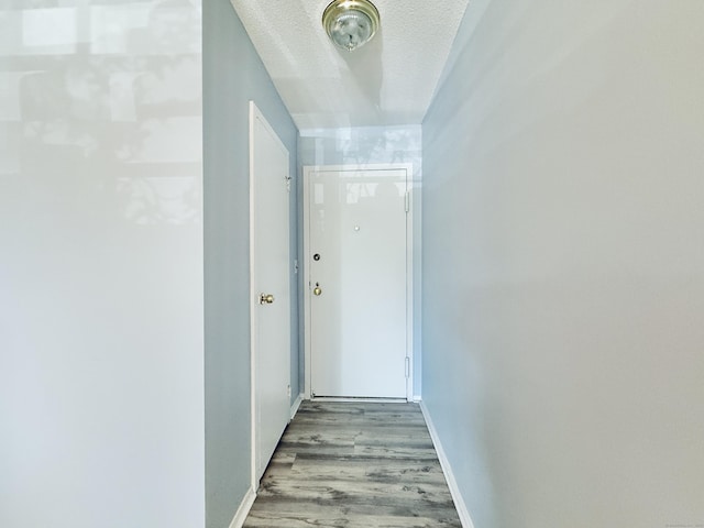1 Strawberry Hill Ct Apt 1A, Stamford, CT 06902 - corridor featuring wood finished floors, a textured ceiling, and baseboards