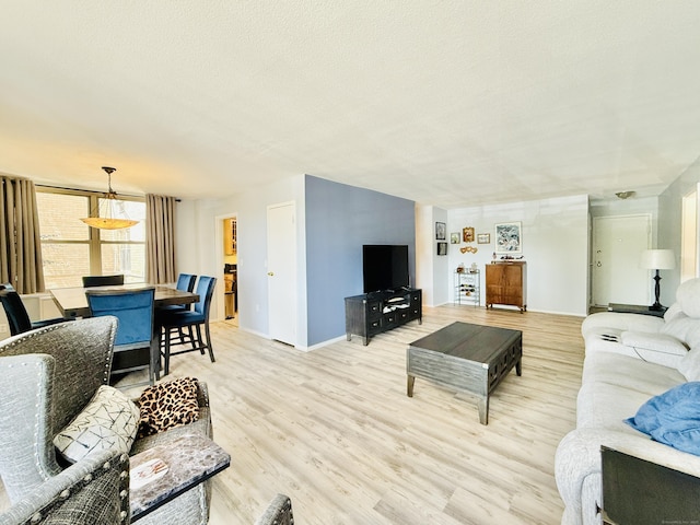 1 Strawberry Hill Ct Apt 1A, Stamford, CT 06902 - living room with light wood-type flooring, a textured ceiling, and baseboards