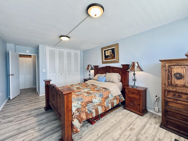 1 Strawberry Hill Ct Apt 1A, Stamford, CT 06902 - bedroom featuring a textured ceiling, light wood finished floors, a closet, and baseboards