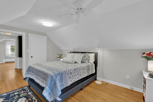 10 Knollwood Rd, Farmington, CT 06032 - bedroom with radiator heating unit, light wood finished floors, baseboards, vaulted ceiling, and a ceiling fan