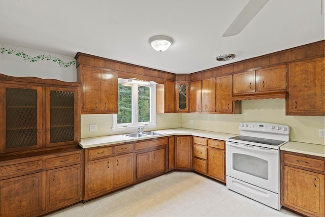 654 Beach Pond Rd, Voluntown, CT 06384 - kitchen with white electric stove, a sink, and brown cabinets