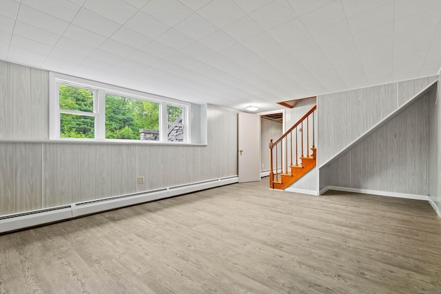 654 Beach Pond Rd, Voluntown, CT 06384 - unfurnished living room with a baseboard heating unit, wood finished floors, stairs, and wood walls